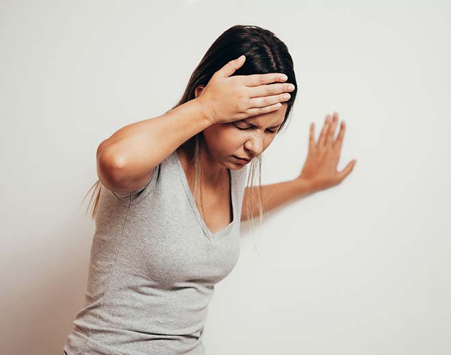 Person holding head feeling dizzy