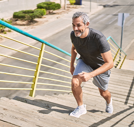 Active adult climbing outdoor stairs