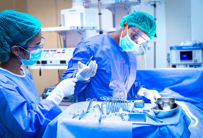 Surgeons preparing instruments in operating room